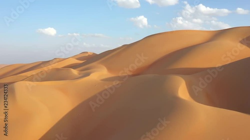 Aerial drone view of massive yellow and gold sand dunes with shadows in empty quarter during sunset. Abu Dhabi, UAE. photo