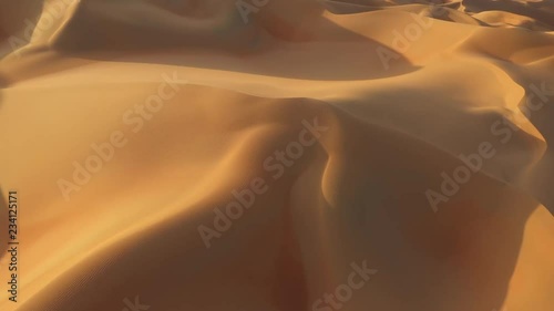 Aerial drone view of massive yellow and gold sand dunes with shadows in empty quarter during sunset. Abu Dhabi, UAE. photo