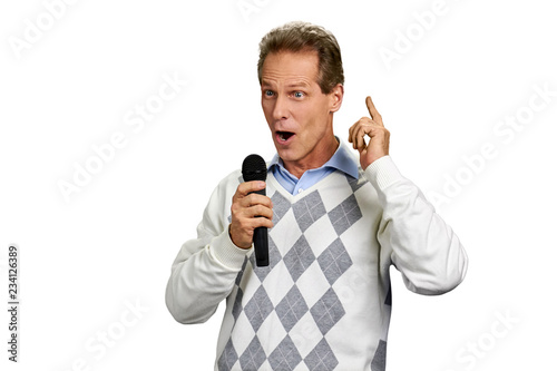 Man talking into microphone on white background. Middle-aged caucasian man holding microphone and gesticulating on white background.
