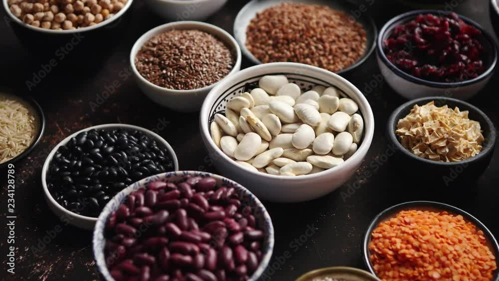 Various superfoods in smal bowls on dark rusty background. Superfood as rice, lentil, beans, peas, goji, flaxseed, buckwheat, couscous, chickpeas Above view Flat lay Various superfoods in smal bowls on dark rusty background. Superfood as rice, lentil, beans, peas, goji, flaxseed, buckwheat, couscous, chickpeas Above view Flat lay
