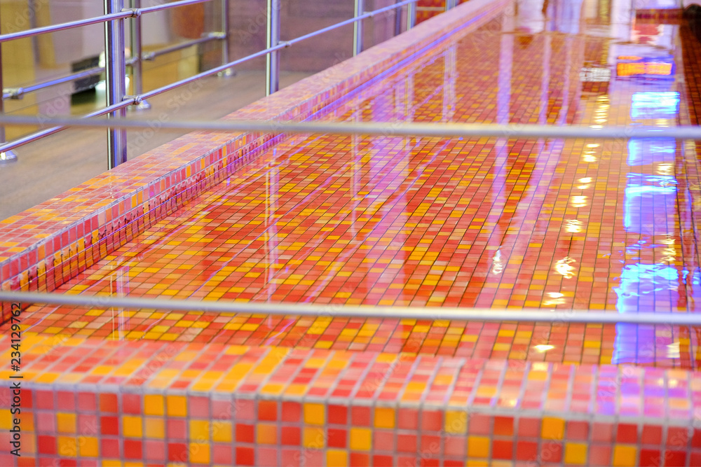 water in the pool with red-orange decorative tiles