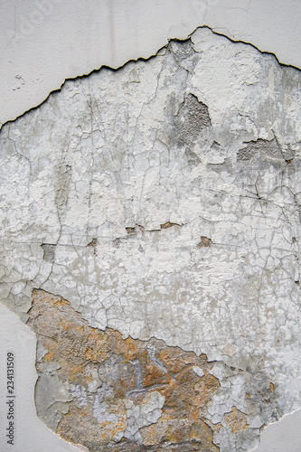 Old white cracked wall. Ragged walls with chapped paint on the surface.