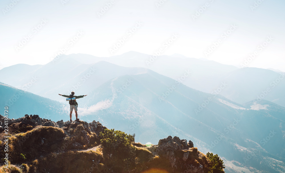 Fototapeta premium Turysta górski z plecakiem Mała figurka stoi na szczycie góry