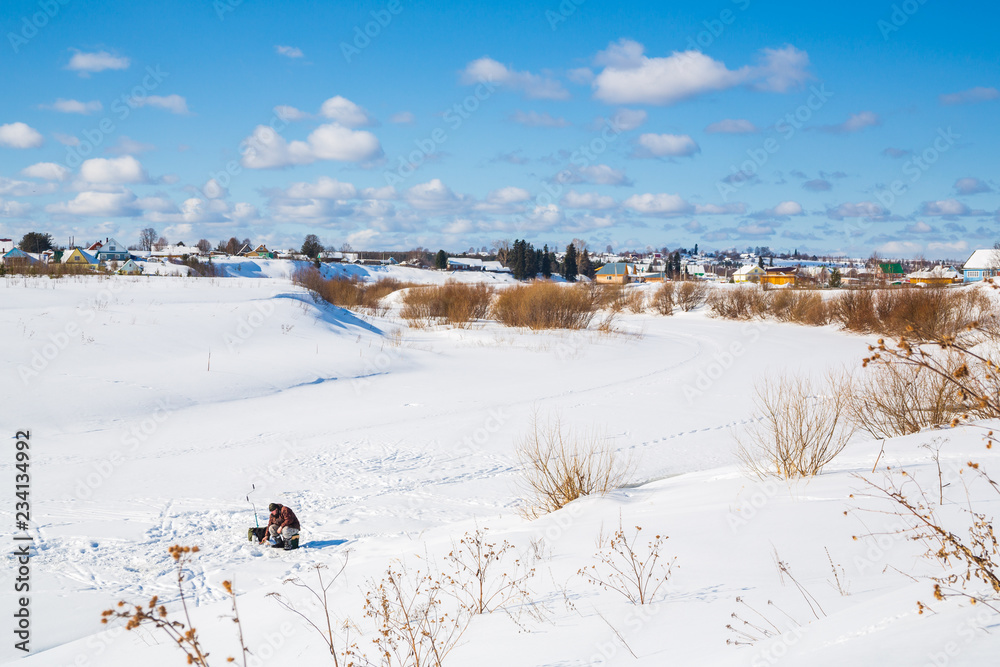 Winter landscape. Countryside. Frozen river. Sunny day. Blue sky. White clouds.