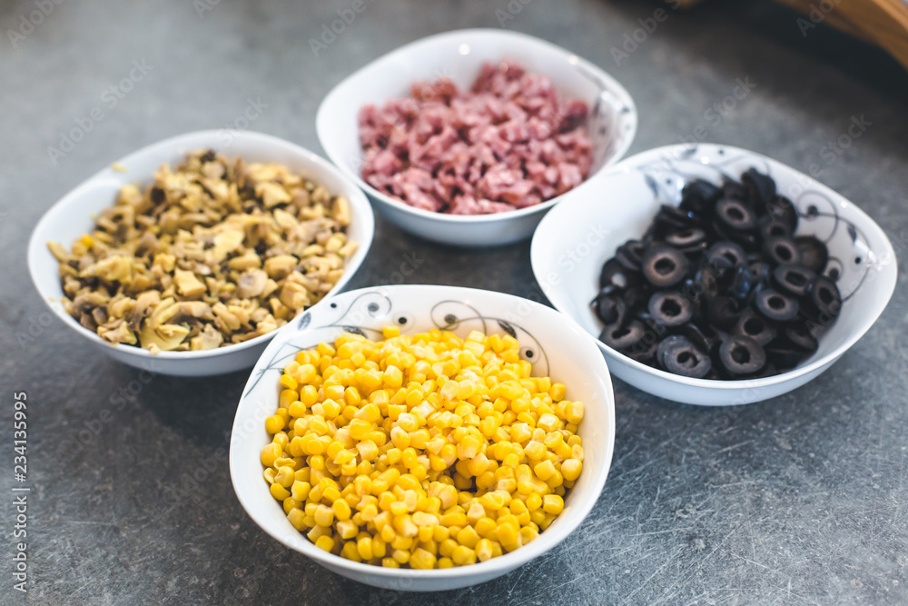 Pizza ingredients, corn, olive and salami in coup. Pizza ingredients, corn, olive and salami in coup.