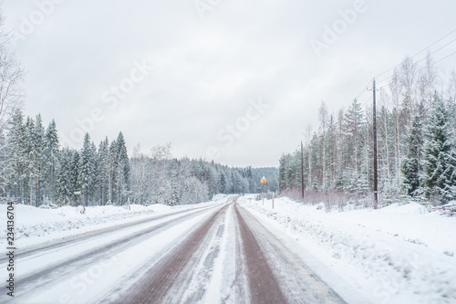 Car with lights on a snow covered road. © dima