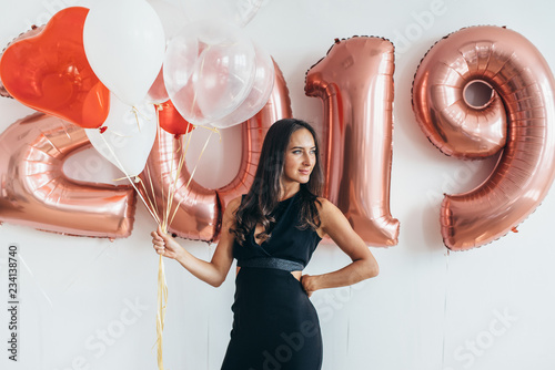 Happy young woman holding balloons Holiday party