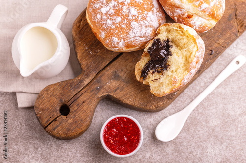 Tasty sweet sugary chocolate donuts with raspberry jam and milk photo