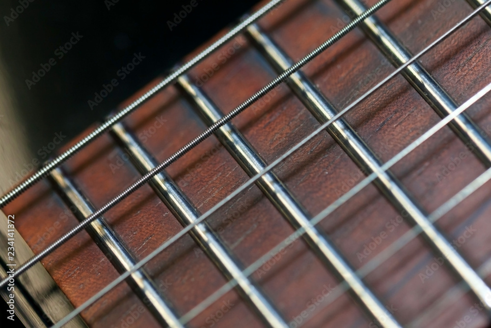 guitar  with wooden brown neck and strings, close up blurry background, texture, abstract