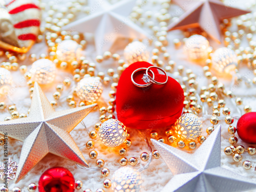 Christmas and New Year star decorations on white knitted background. Red  heart gift box with wedding diamond rings, metal light bulbs with delicate  pattern, golden beads. Stock Photo | Adobe Stock