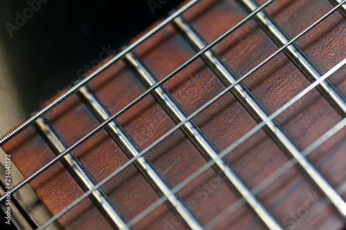 guitar with wooden brown neck and strings, close up blurry background, texture, abstract