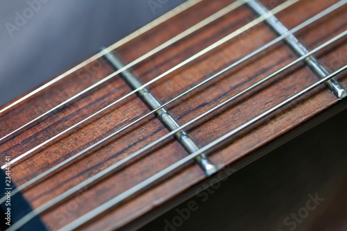 guitar with wooden brown neck and strings, close up blurry background, texture, abstract