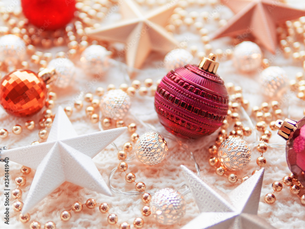 Christmas and New Year star decorations on white knitted background. Metal light bulbs with delicate pattern, golden beads, red balls. Christmas and New Year star decorations on white knitted background. Metal light bulbs with delicate pattern, golden beads, red balls.