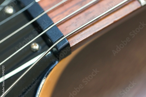 guitar with wooden brown neck and strings, close up blurry background, texture, abstract