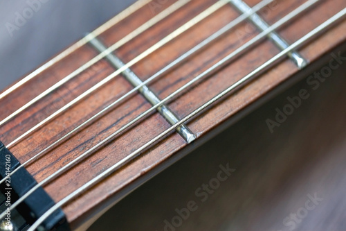 guitar with wooden brown neck and strings, close up blurry background, texture, abstract