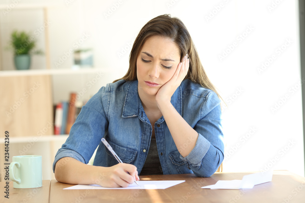 Worried woman writing notes or a letter Worried woman writing notes or a letter