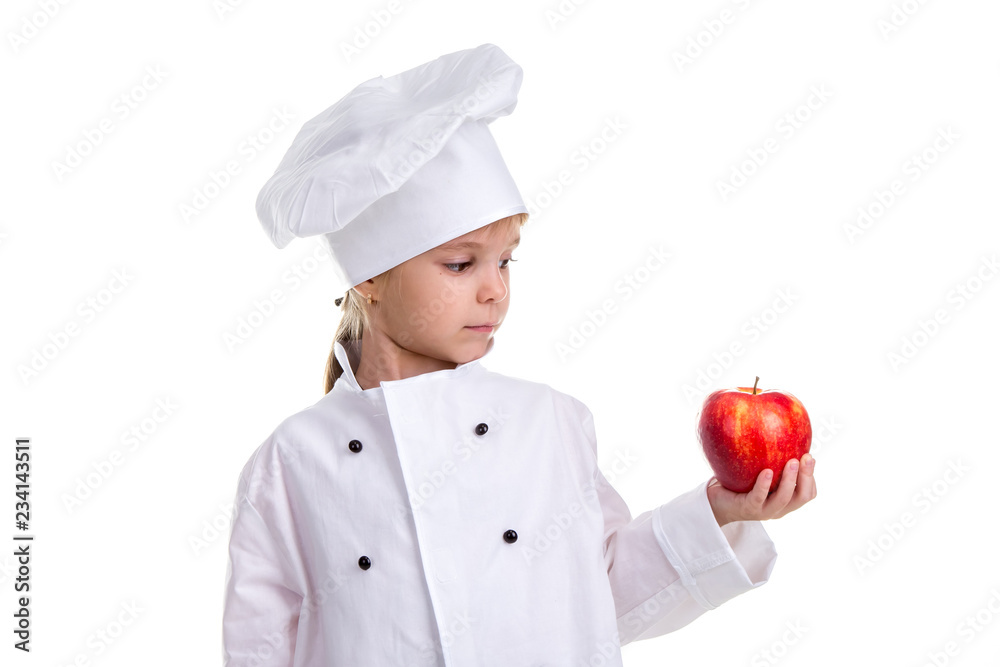 Chef girl in a cap cook uniform, holding the red apple. Looking at the apple. Human emotions, facial expression feeling, attitude Chef girl in a cap cook uniform, holding the red apple. Looking at the apple. Human emotions, facial expression feeling, attitude