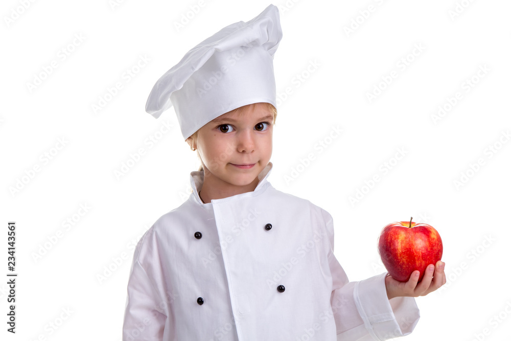 Chef girl in a cap cook uniform, holding the red apple. Looking at the camera. Human emotions, facial expression feeling, attitude Chef girl in a cap cook uniform, holding the red apple. Looking at the camera. Human emotions, facial expression feeling, attitude