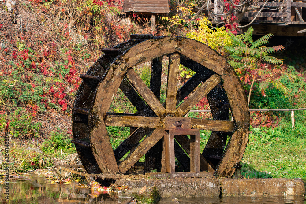 Working watermill wheel with falling water in the village Working watermill wheel with falling water in the village