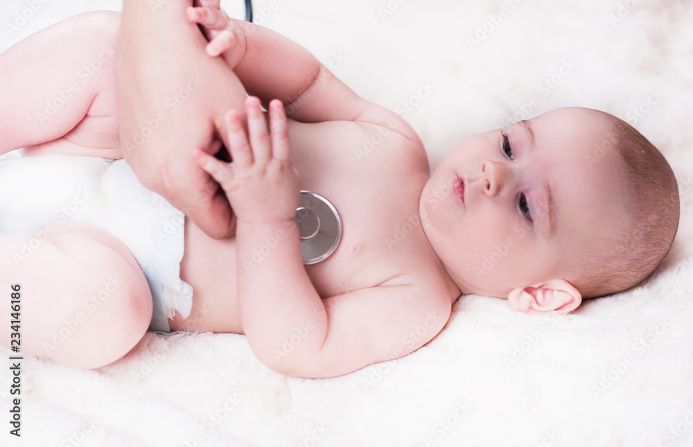 A very small child, a baby, lies back at the doctor's office and the doctor listens to the lungs, the heart. A very small child, a baby, lies back at the doctor's office and the doctor listens to the lungs, the heart.