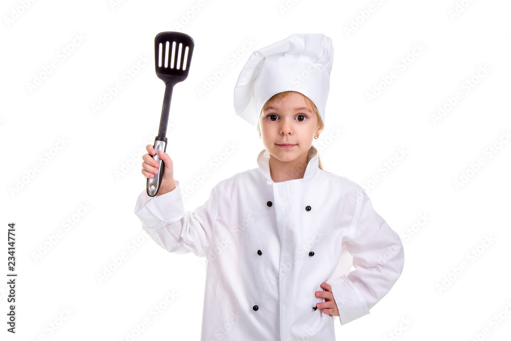 Girl chef white uniform isolated on white background. Holding black scapula up with another hand on the waist. Looking at the camera. Landscape image Girl chef white uniform isolated on white background. Holding black scapula up with another hand on the waist. Looking at the camera. Landscape image