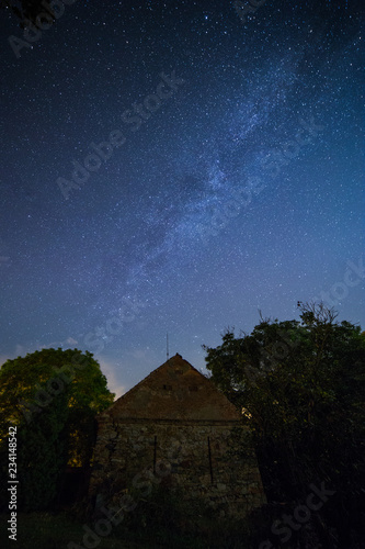 Milky way over old brick and stone building