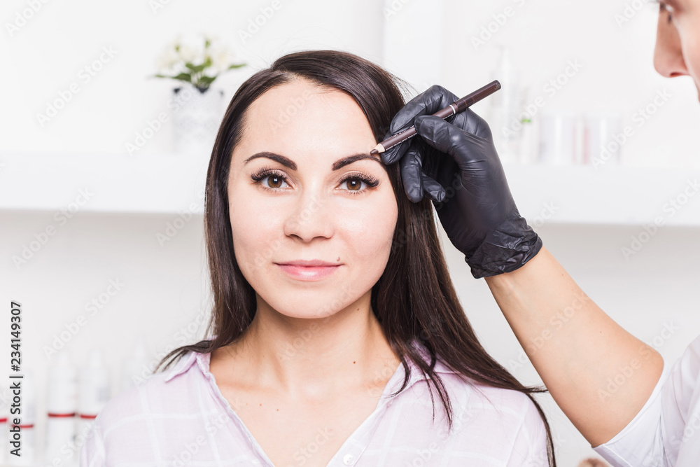 Permanent makeup for eyebrows of beautiful young woman in beauty salon Permanent makeup for eyebrows of beautiful young woman in beauty salon