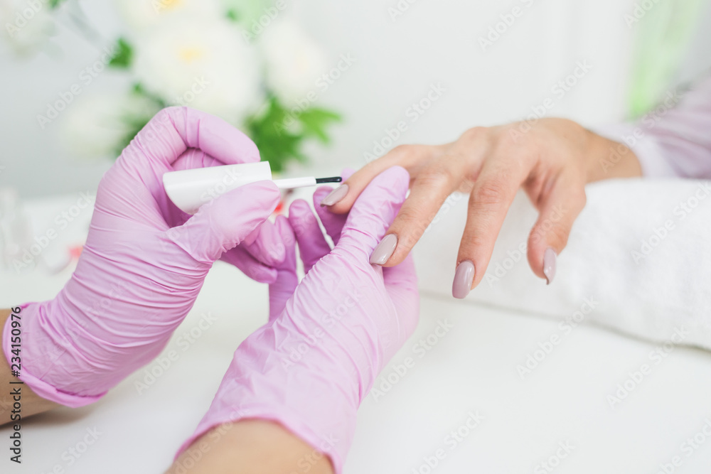 Young woman getting manicure in beauty salon. Close-up Young woman getting manicure in beauty salon. Close-up