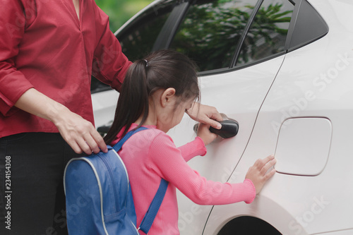 фотографія Back to school concept, Beautiful young asian mother or parent helping daughter or pupil to getting in the white car to ride to school, Selective focus