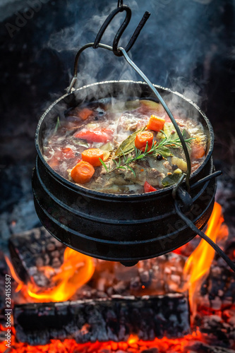 Tasty and homemade hunter's stew on campfire