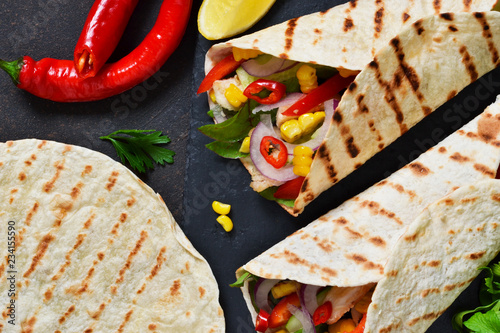 Taco - traditional dish of Mexican cuisine. Mexican tacos with beef, vegetables and sauce. Top view.