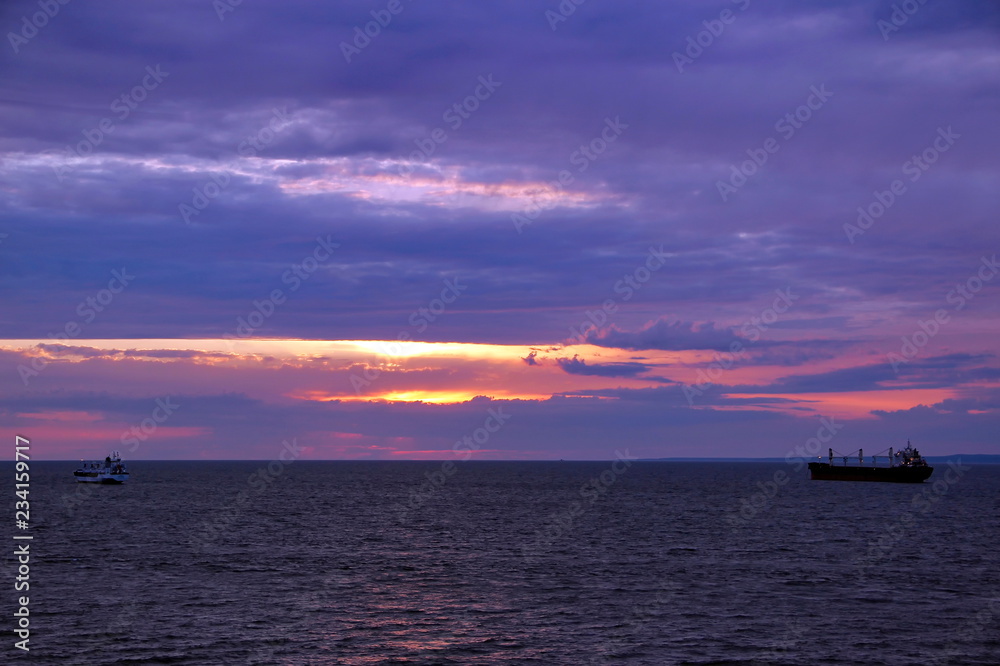 sunset over the sea and the ships sailing away