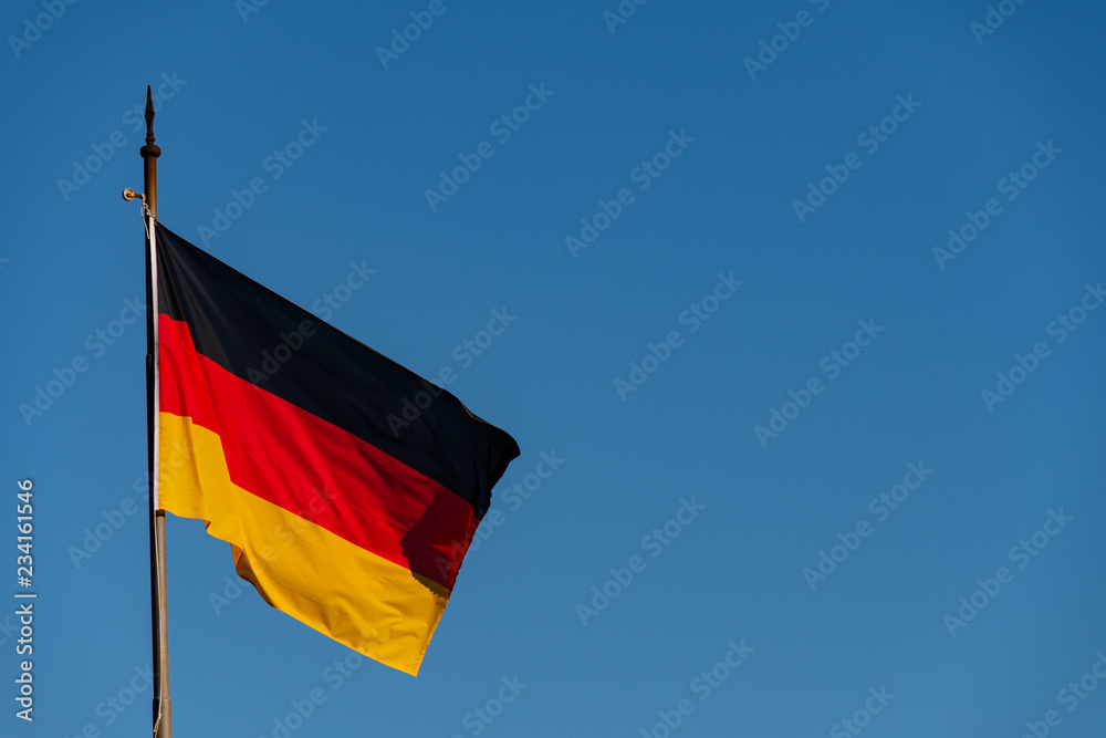 German flag waving in the wind against a clear sky German flag waving in the wind against a clear sky