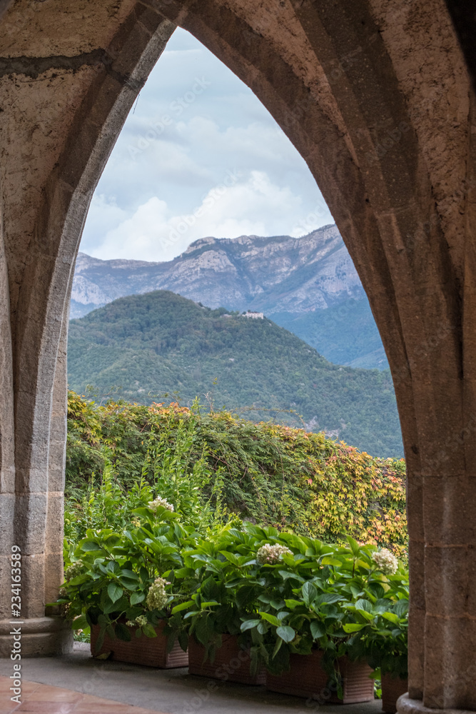 Ravello, Italy. The gothic style crypt at the Gardens of Villa Cimbrone, Ravello on the Amalfi Coast in Italy. There is a lovely view of the mountains through the arches of the crypt. Ravello, Italy. The gothic style crypt at the Gardens of Villa Cimbrone, Ravello on the Amalfi Coast in Italy. There is a lovely view of the mountains through the arches of the crypt.