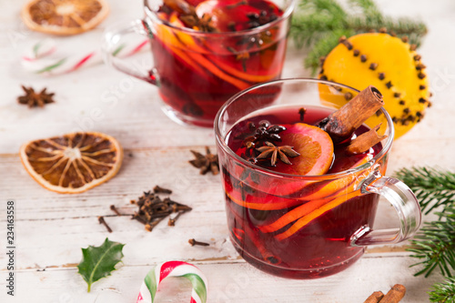 Christmas hot mulled wine with spices on wooden background.