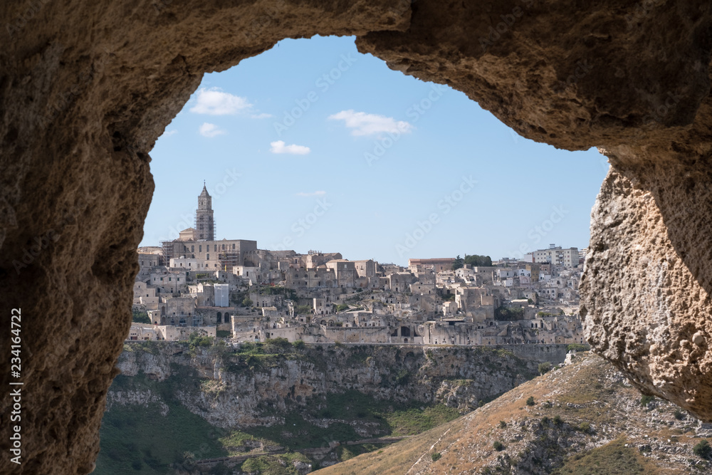 Panorama of houses built into the rock in the cave city of Matera, Basilicata Italy. Matera has been designated European Capital of Culture for 2019. Photographed from inside a cave across the ravine.