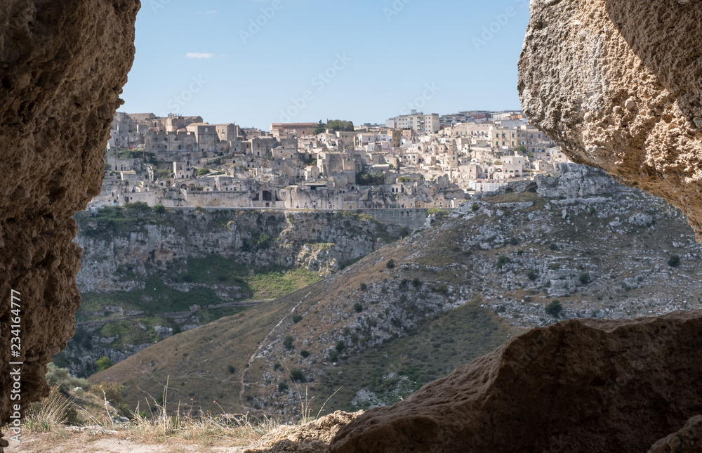 Houses built into the rock in the cave city of Matera, Basilicata Italy. Matera has been designated European Capital of Culture for 2019. Photographed from inside a cave in the ravine opposite.
