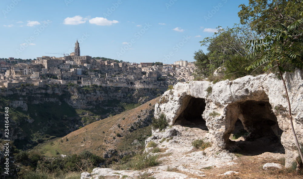Panorama of houses built into the rock in the cave city of Matera, Basilicata Italy. Matera has been designated European Capital of Culture for 2019. Photographed from inside a cave across the ravine.