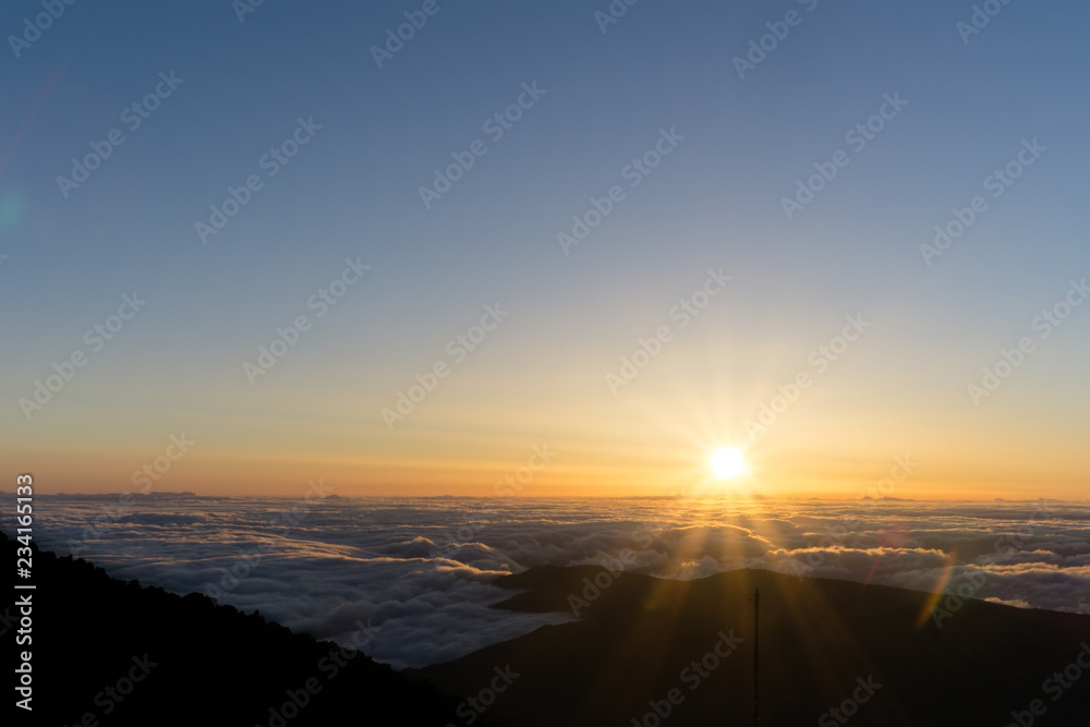 View from volcano Pico del Teide in Tenerife, right at sunrise time with a glowing sea of clouds reaching to the horizon