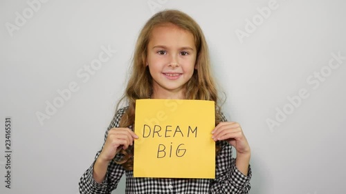 Smiling teenage girl shows into the camera phrase dream big photo