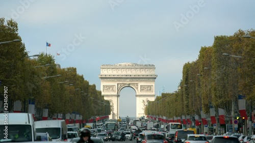 Arc de Triomphe in Paris seen from Champs Elysees on a sunny day with traffic