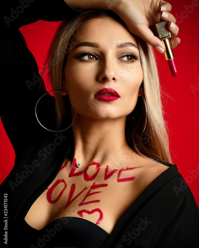 Beautiful sexy woman makeup artist hold red lipstick rouge with love text on body photo