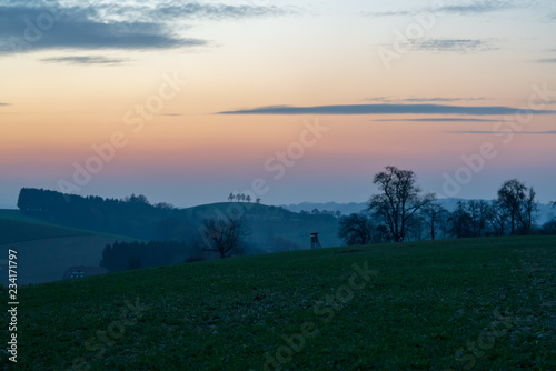 Jagdhochstand in Hügellandschaft bei Sonnenuntergang © lexpixelart