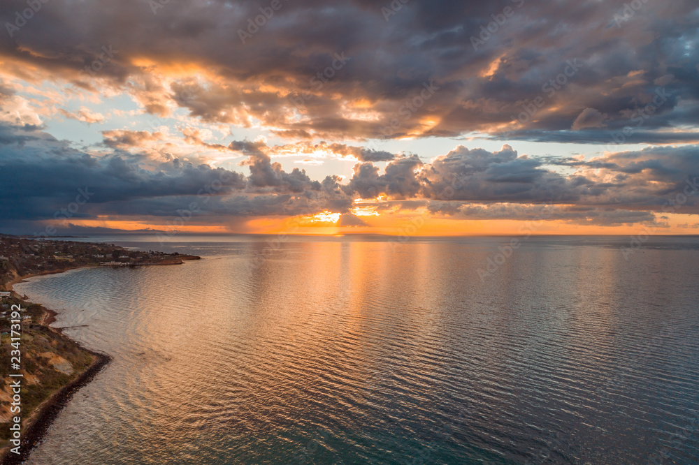 Glowing orange sunset over Port Phillip Bay near Mornington Peninsula coastline Glowing orange sunset over Port Phillip Bay near Mornington Peninsula coastline