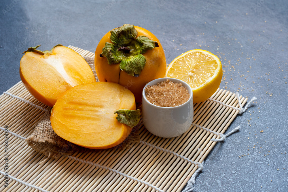 Delicious ripe persimmon fruit on wooden background