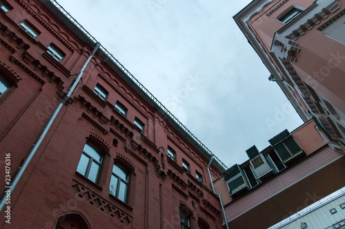 Canvas Print View of the evening city sky from the courtyard bounded by the old red brick bui