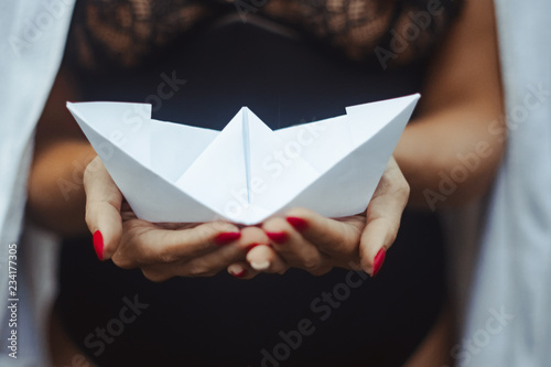 girl holding a paper boat