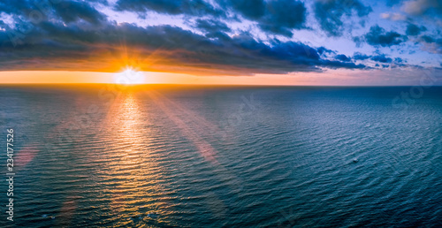 Lonely boat in wast ocean at sunset - wide aerial panorama © Greg Brave