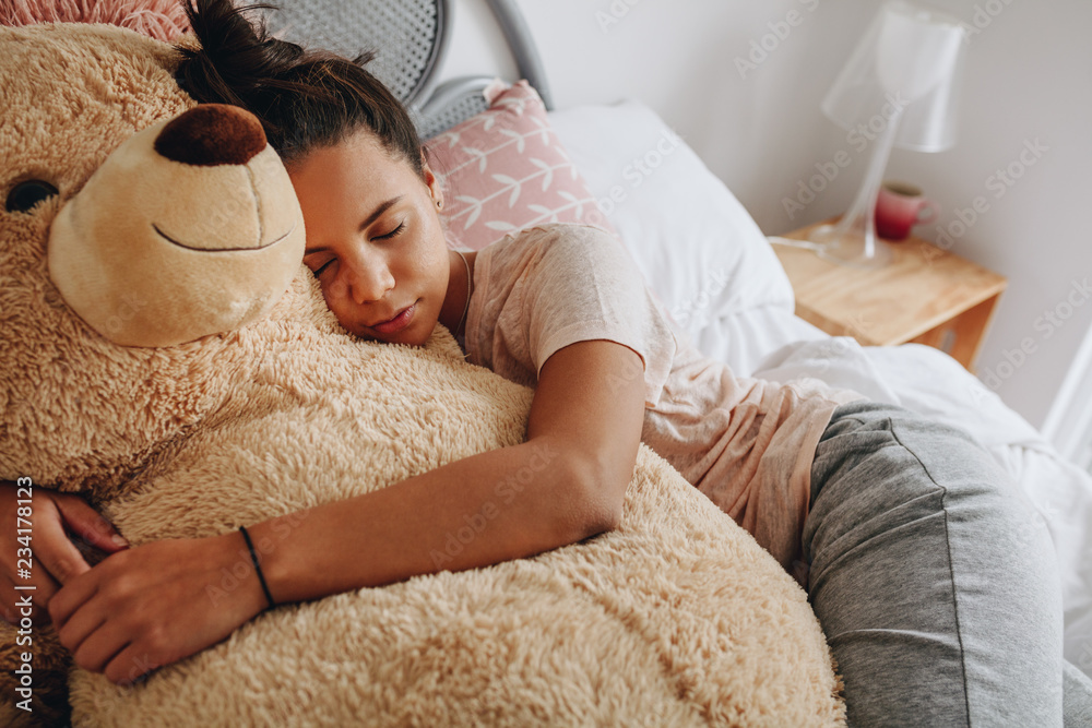 Girl sleeping on bed holding a teddy bear Girl sleeping on bed holding a teddy bear