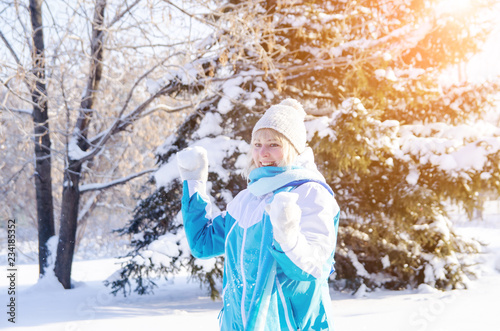beautiful smiling blonde girl playing snowballs